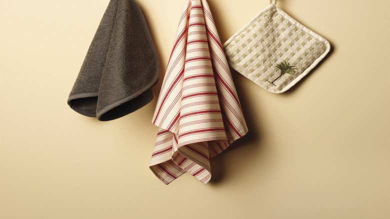 Close up of towels and pot holders hanging from hooks