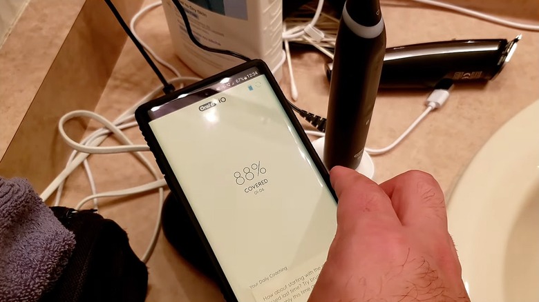 Person using NFC tag to launch toothbrush app