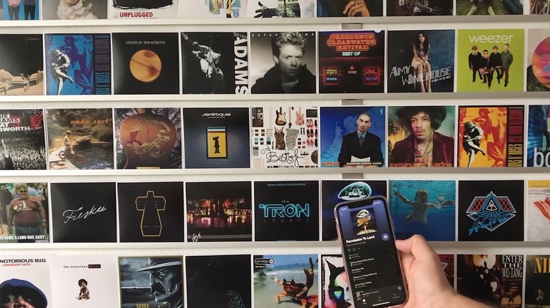 Closeup of a person using a phone to scan an NFC tag on a music wall