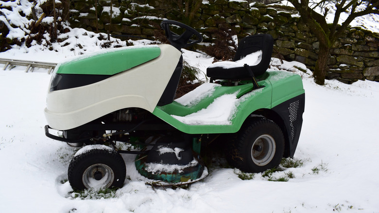 Riding lawn mower covered in snow