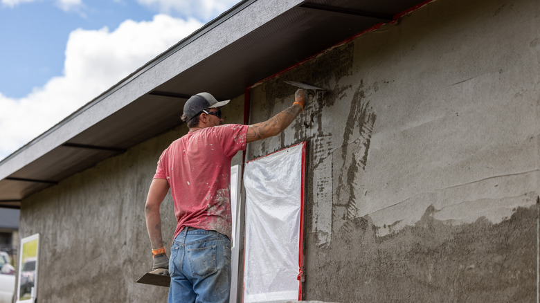 Man applying stucco to a wall outdoors