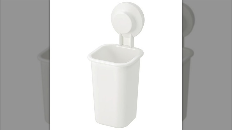 Narrow white basket placed on wall with suction cup
