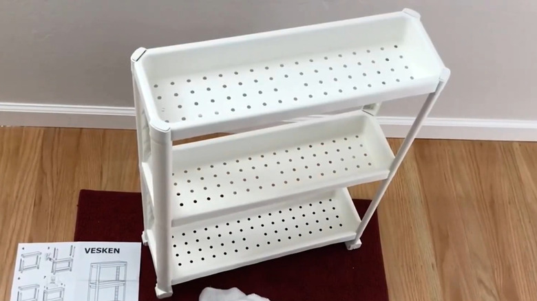 Organizer cart holding jarred items next to cupboards