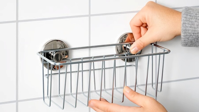 Steel basket being hung on a wall with suction cups