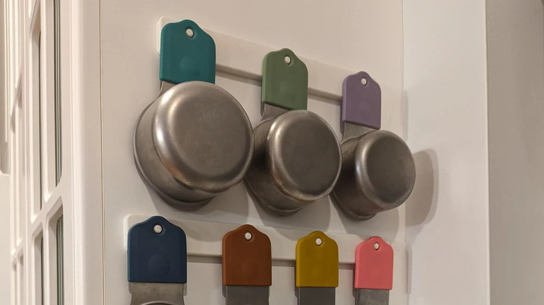 Close up of measuring cups secured to wall with magnets