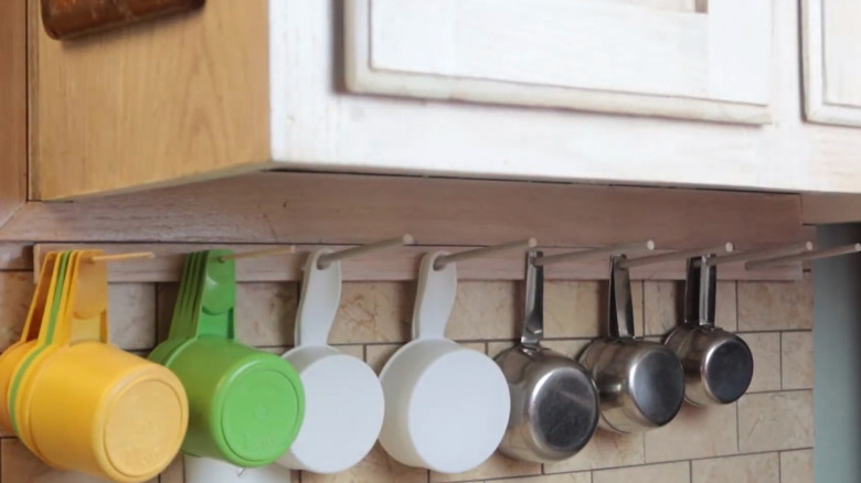 Close up of measuring cups hanging from wall rack