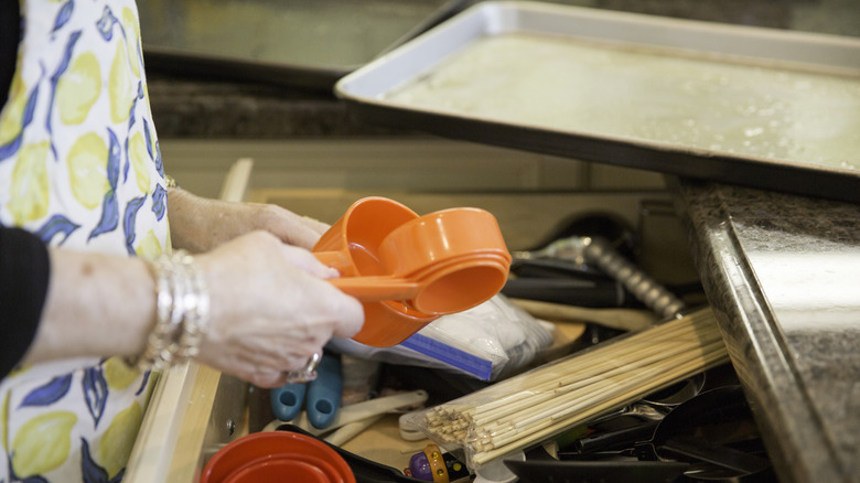 Close up of person organizing measuring cups