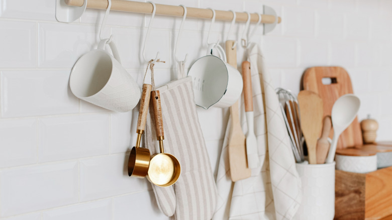 Close up kitchen tools hanging from bar on wall