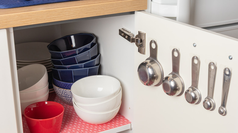 Close up of measuring cups hanging on cabinet door