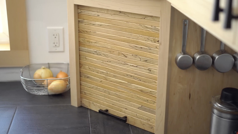 A kitchen counter cabinet fitted with a roll shutter door