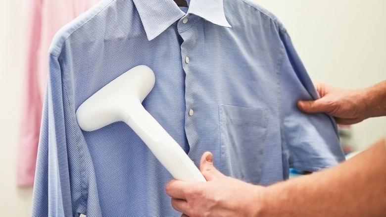 person steaming collared shirt