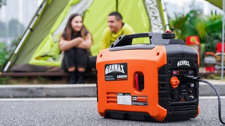 a GENMAX GM200i Home Backup Generator sitting on concrete in a camping site