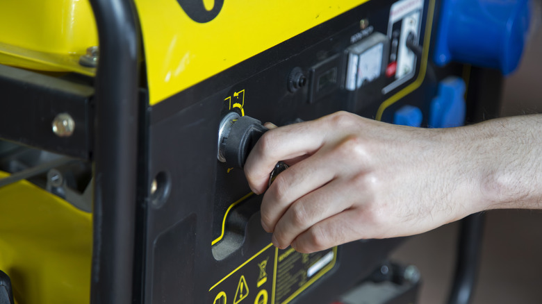 a man switching on a Portable gasoline generator