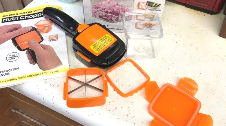 Unpacked novelty food chopper multi tool on kitchen countertop with instruction manual