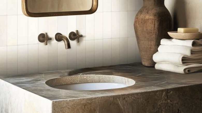 A bathroom vanity with a granite countertop and zellige tile backsplash.