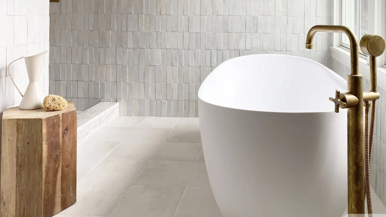 A bathroom with white zellige tile walls and a matte ceramic floor.
