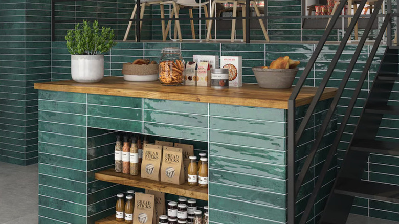 Green zellige tile walls and kitchen counter with a wooden countertop.