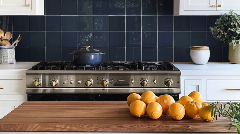 A blue zellige tile backsplash with a stainless steel stovetop.