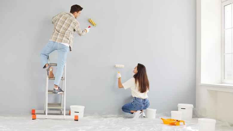 Couple painting the walls together