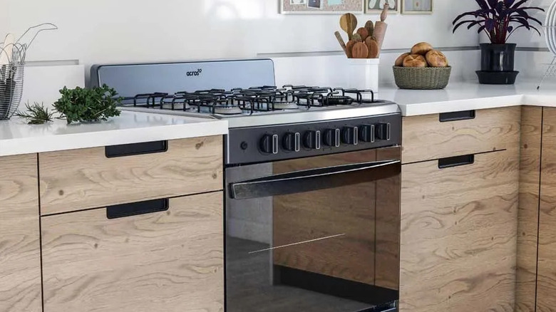 A shot of a kitchen with an Acros range oven between wooden cabinets