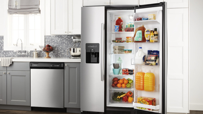 A shot of a kitchen with an open Amana side-by-side refrigerator