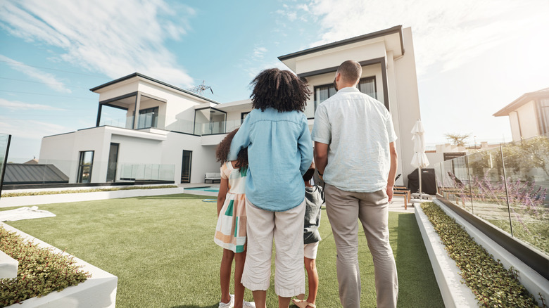 A family admiring their home from the outside