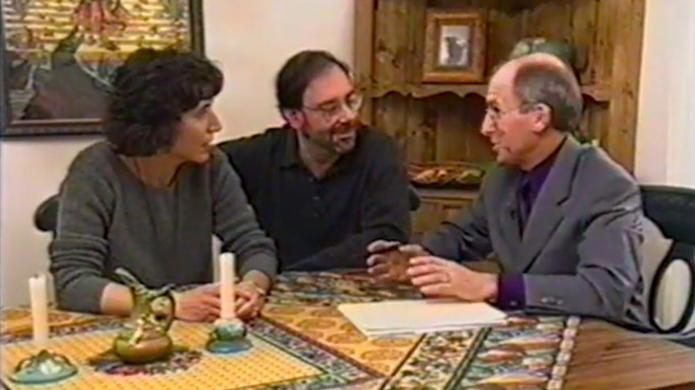 Three people sitting at a table on an HGTV show.