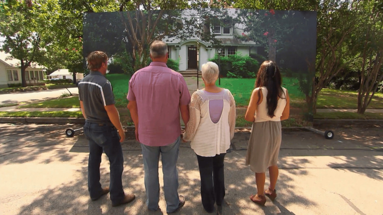 Four people standing in front of a house.