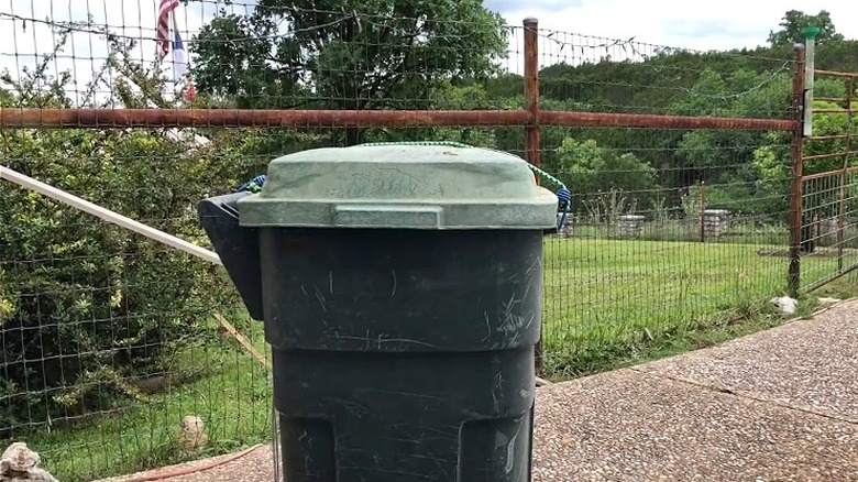 Trash can secured with a bungee cord