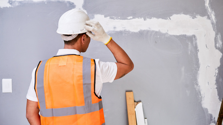A construction working scratching their head in confusion