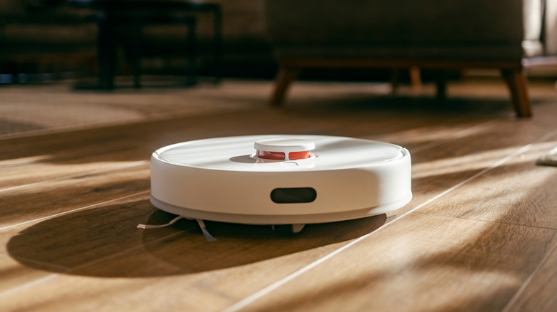 A person relaxing at home as a robot vacuum handles the cleaning