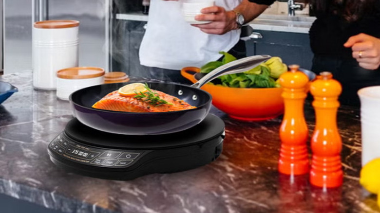 NuWave induction cooktop on countertop with ingredients for food.