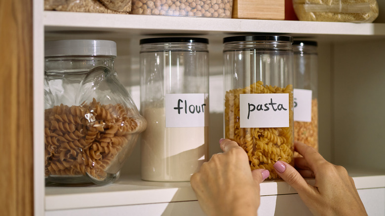Close-up of a person organizing a pantry cabinet