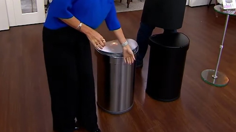 Woman placing her hand against the sensor of a trash can