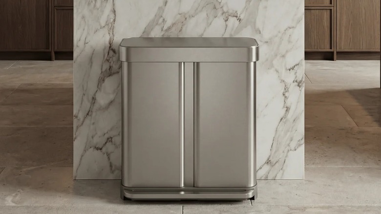 A large two-compartment stainless steel trash can in a modern kitchen