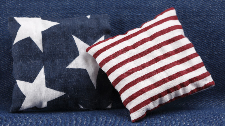 Patriotic throw pillows sit on a denim-clad couch