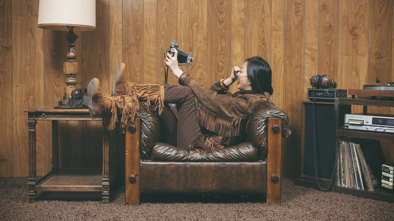A woman lounging in retro chair in a 1970s style living room