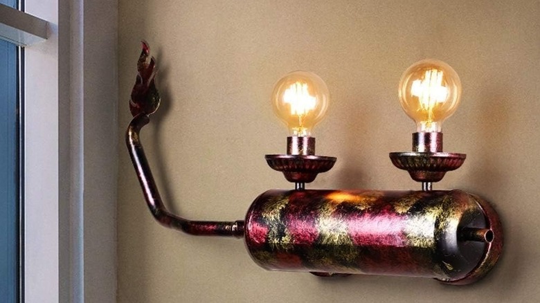 A wall-mounted light fixture made from the exhaust pipe of a motorcycle.