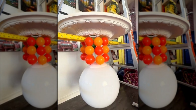 Chandelier with hanging ball pit balls and one oversized white ball hanging center and lower