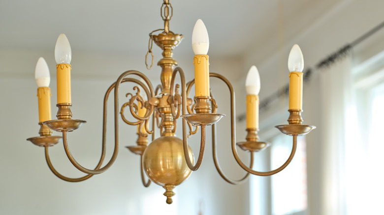 A classic brass chandelier hanging from a dining room ceiling