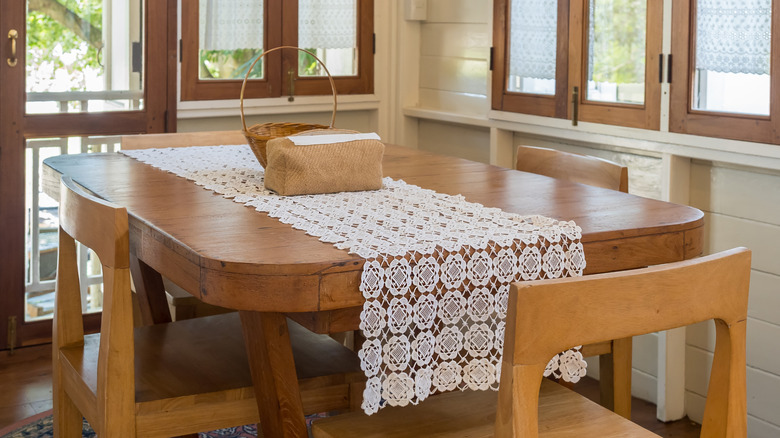 A wooden table with a single white runner down the middle