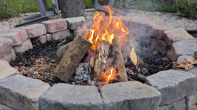 A stone fire pit with logs burning