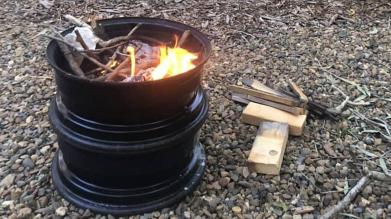A fire pit made of two tire rims with burning wood