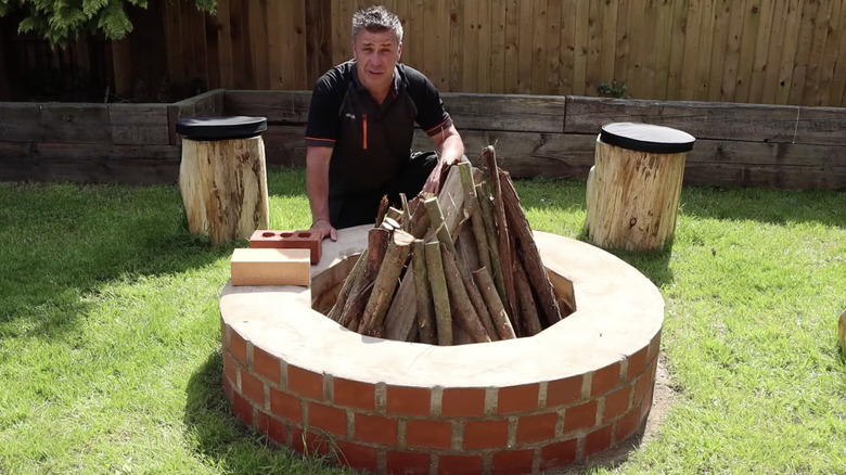 A brick and mortar fire pit with unburnt logs