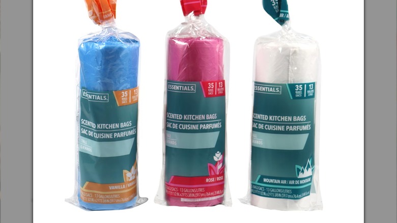 A woman holding the pink Dollar Tree scented trash bags in the store.