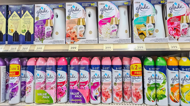 A woman holding handfuls of Dollar Tree air fresheners.