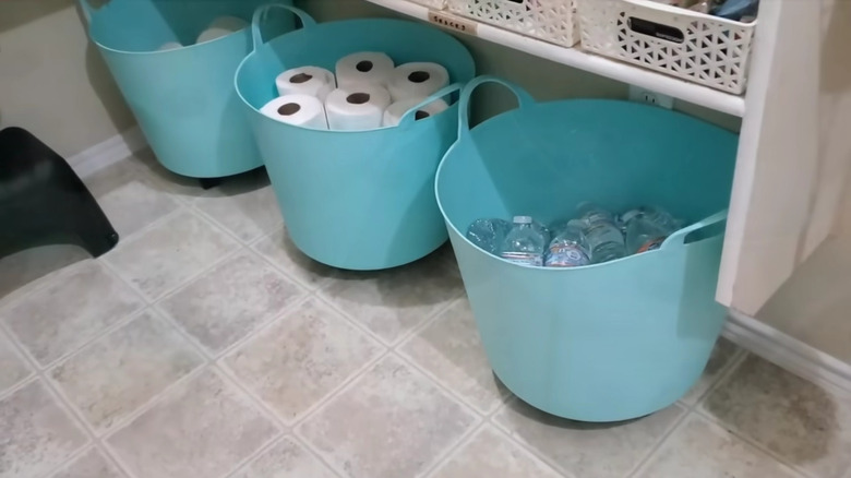 Toilet paper rolls stored in a large plastic bins
