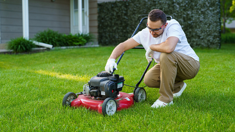 Man inspecting lawn mower