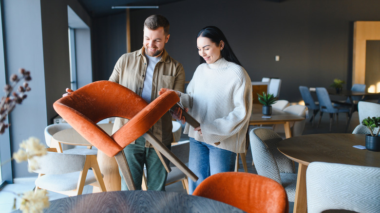 A couple examining a set of new chairs in a showroom