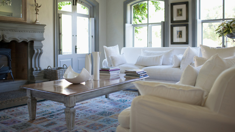 A living room with matching all-white sofas